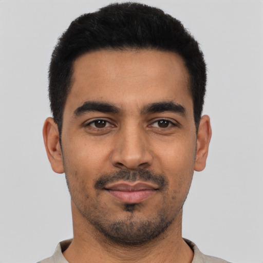 Joyful latino young-adult male with short  black hair and brown eyes
