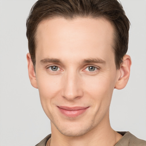 Joyful white young-adult male with short  brown hair and grey eyes