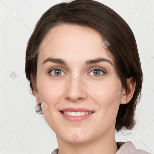 Joyful white young-adult female with medium  brown hair and grey eyes