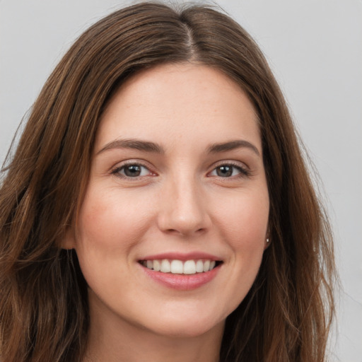 Joyful white young-adult female with long  brown hair and grey eyes