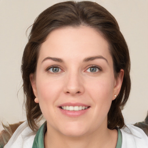 Joyful white young-adult female with medium  brown hair and green eyes