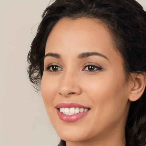 Joyful latino young-adult female with long  brown hair and brown eyes