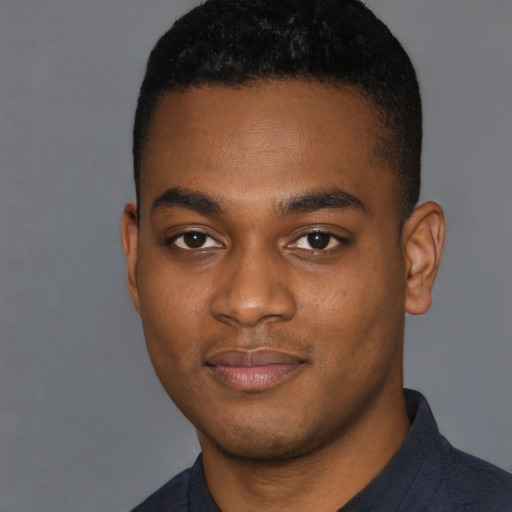 Joyful black young-adult male with short  black hair and brown eyes