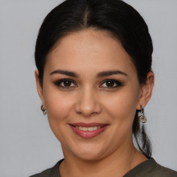 Joyful latino young-adult female with medium  brown hair and brown eyes