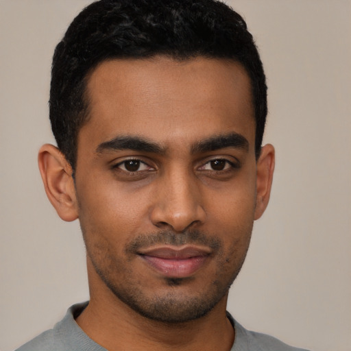 Joyful latino young-adult male with short  black hair and brown eyes