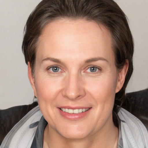 Joyful white adult female with medium  brown hair and grey eyes