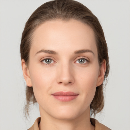 Joyful white young-adult female with medium  brown hair and grey eyes