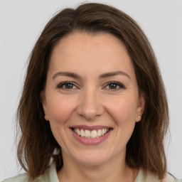 Joyful white adult female with medium  brown hair and brown eyes