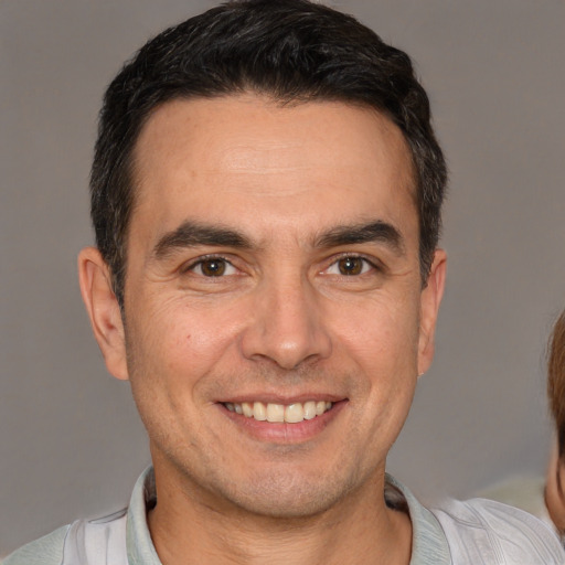 Joyful white adult male with short  brown hair and brown eyes