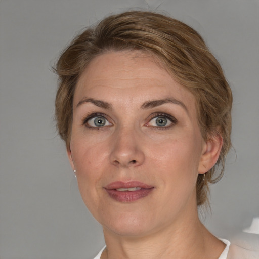 Joyful white adult female with medium  brown hair and blue eyes