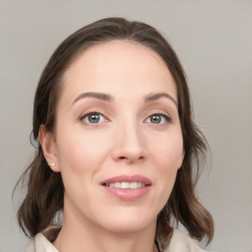 Joyful white young-adult female with medium  brown hair and grey eyes