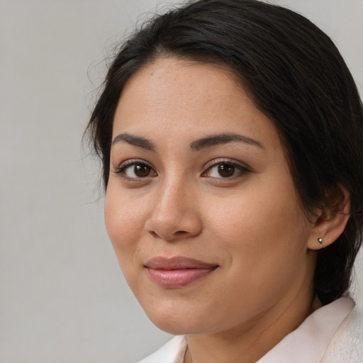 Joyful latino young-adult female with medium  brown hair and brown eyes
