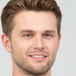 Joyful white young-adult male with short  brown hair and grey eyes