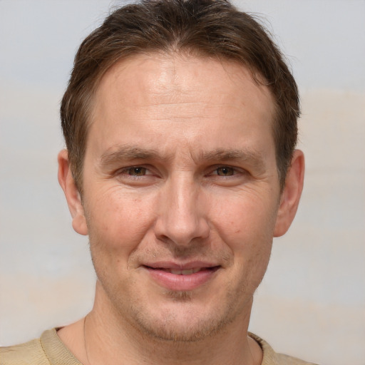 Joyful white adult male with short  brown hair and brown eyes