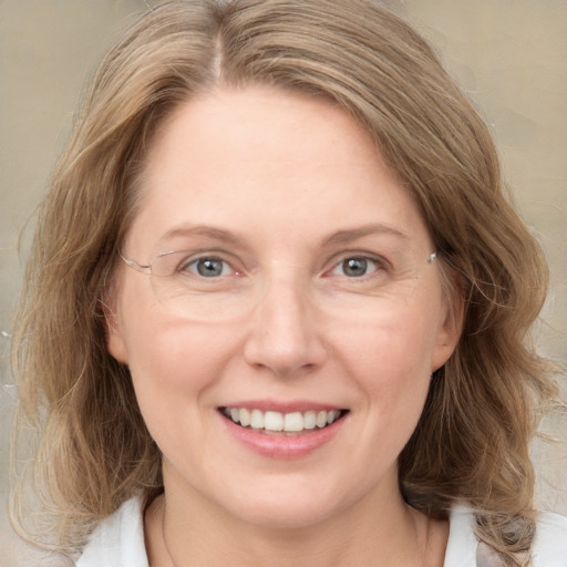 Joyful white adult female with medium  brown hair and blue eyes