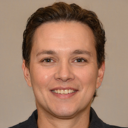 Joyful white adult male with short  brown hair and brown eyes