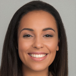 Joyful latino young-adult female with long  brown hair and brown eyes