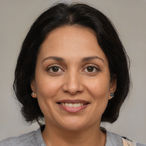 Joyful latino adult female with medium  brown hair and brown eyes