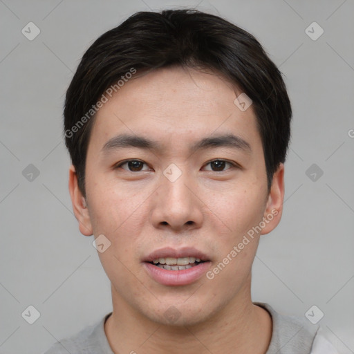 Joyful asian young-adult male with short  brown hair and brown eyes