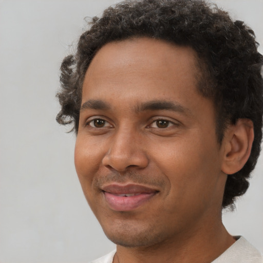 Joyful black young-adult male with short  brown hair and brown eyes