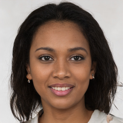 Joyful black young-adult female with medium  brown hair and brown eyes