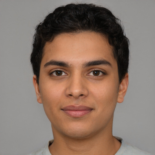 Joyful latino young-adult male with short  brown hair and brown eyes