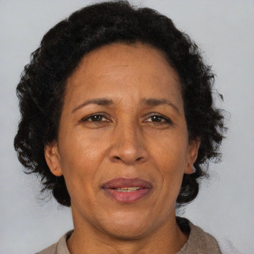Joyful black adult female with short  brown hair and brown eyes