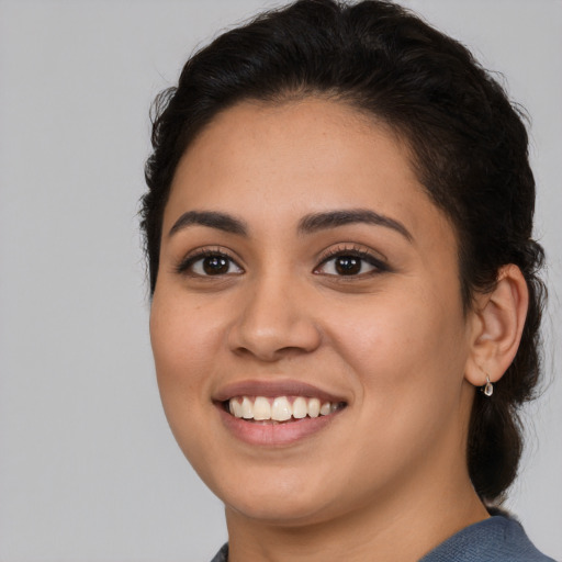 Joyful latino young-adult female with long  brown hair and brown eyes