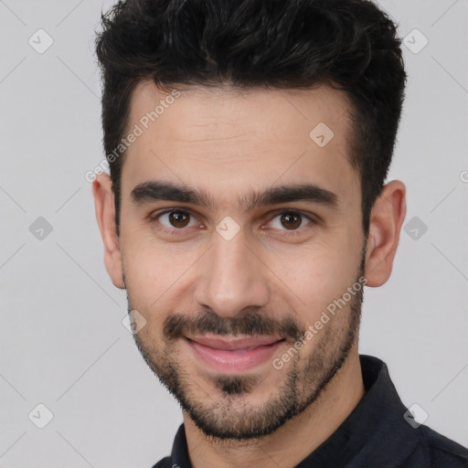 Joyful white young-adult male with short  black hair and brown eyes