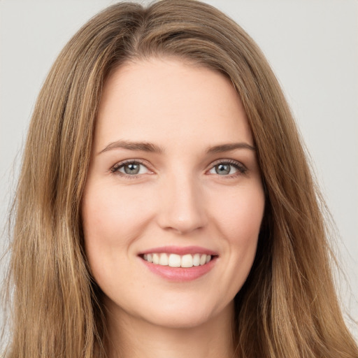 Joyful white young-adult female with long  brown hair and green eyes