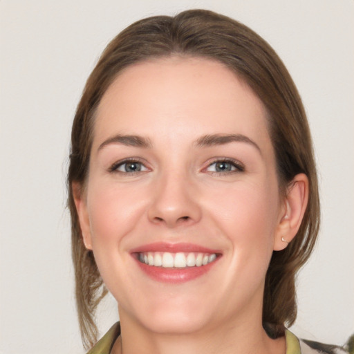 Joyful white young-adult female with medium  brown hair and grey eyes