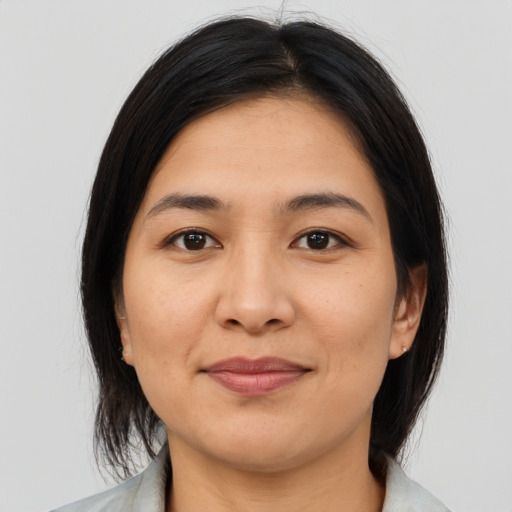 Joyful latino adult female with medium  brown hair and brown eyes