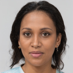 Joyful black adult female with medium  brown hair and brown eyes