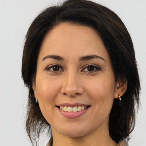 Joyful latino young-adult female with medium  brown hair and brown eyes