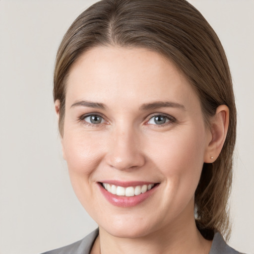 Joyful white young-adult female with medium  brown hair and grey eyes