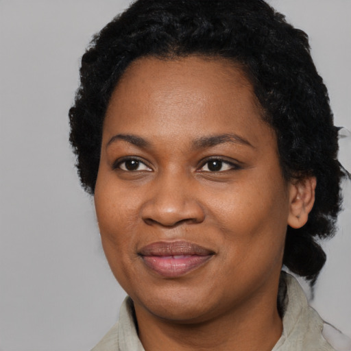 Joyful black adult female with short  black hair and brown eyes