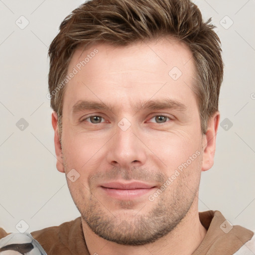 Joyful white young-adult male with short  brown hair and grey eyes