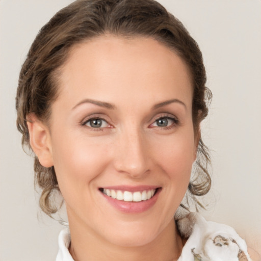 Joyful white young-adult female with medium  brown hair and green eyes