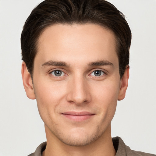 Joyful white young-adult male with short  brown hair and grey eyes