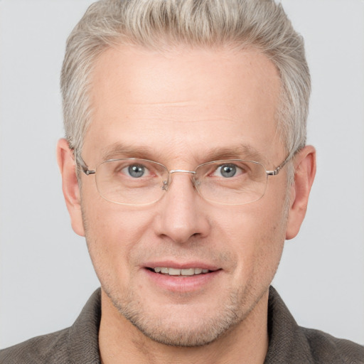 Joyful white middle-aged male with short  blond hair and blue eyes