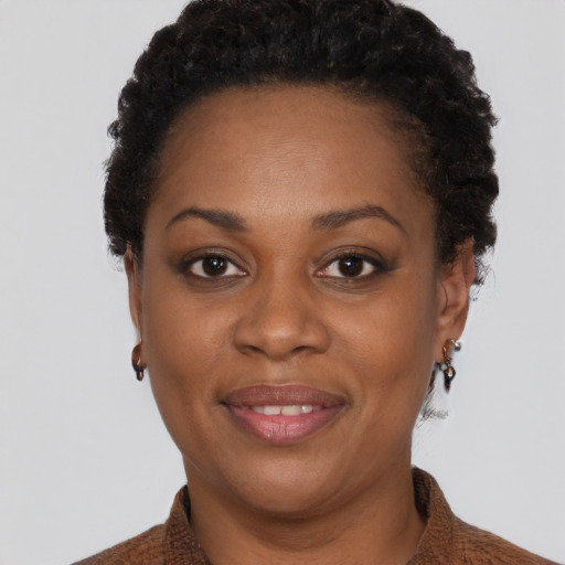 Joyful black young-adult female with short  brown hair and brown eyes