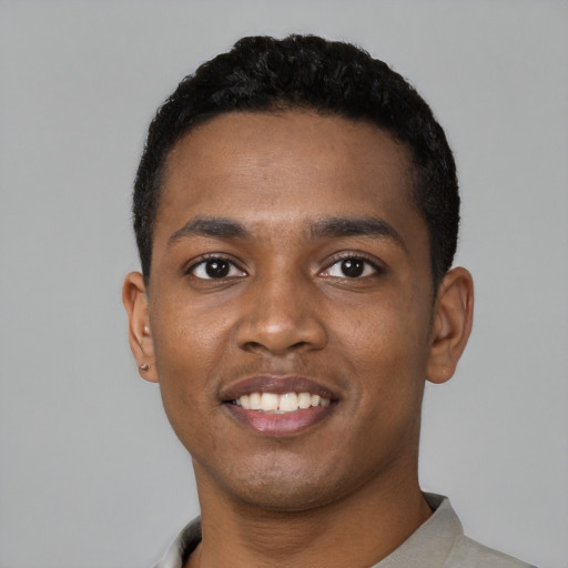 Joyful black young-adult male with short  black hair and brown eyes