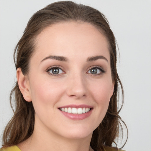 Joyful white young-adult female with medium  brown hair and blue eyes