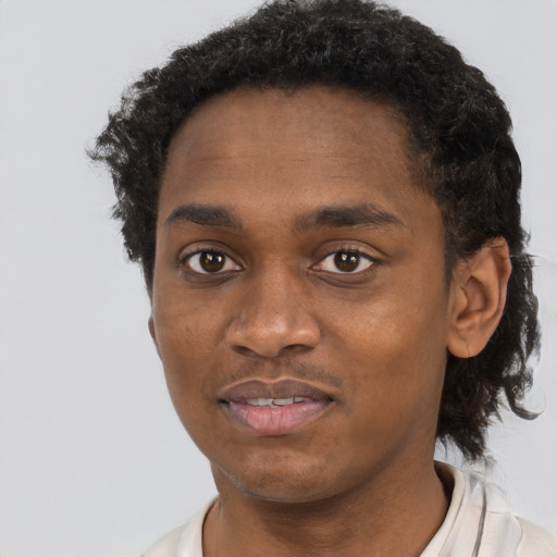 Joyful black young-adult male with short  black hair and brown eyes