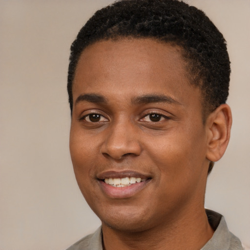 Joyful black young-adult male with short  brown hair and brown eyes