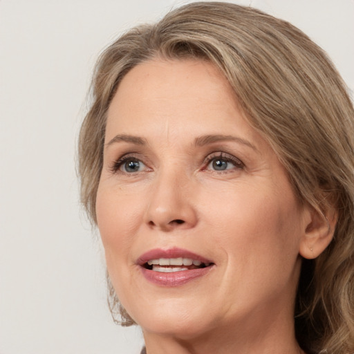 Joyful white adult female with medium  brown hair and grey eyes