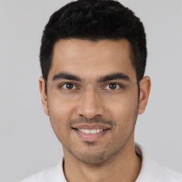 Joyful latino young-adult male with short  black hair and brown eyes