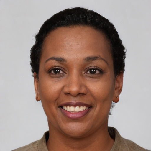 Joyful black adult female with short  black hair and brown eyes