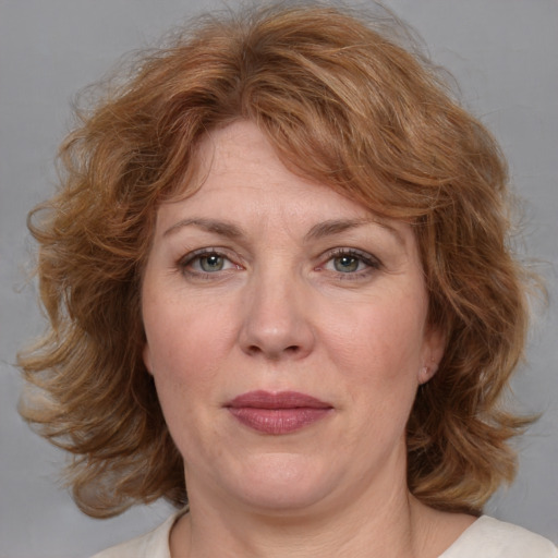 Joyful white adult female with medium  brown hair and blue eyes