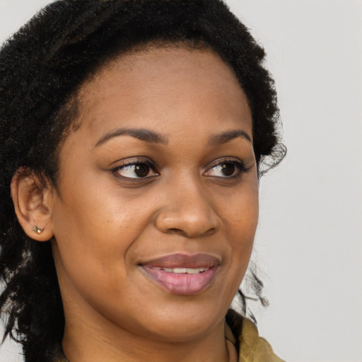 Joyful black young-adult female with long  brown hair and brown eyes